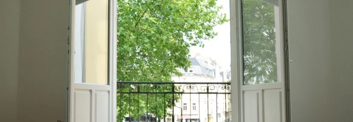 Offene Balkontür mit Blick auf Bäume